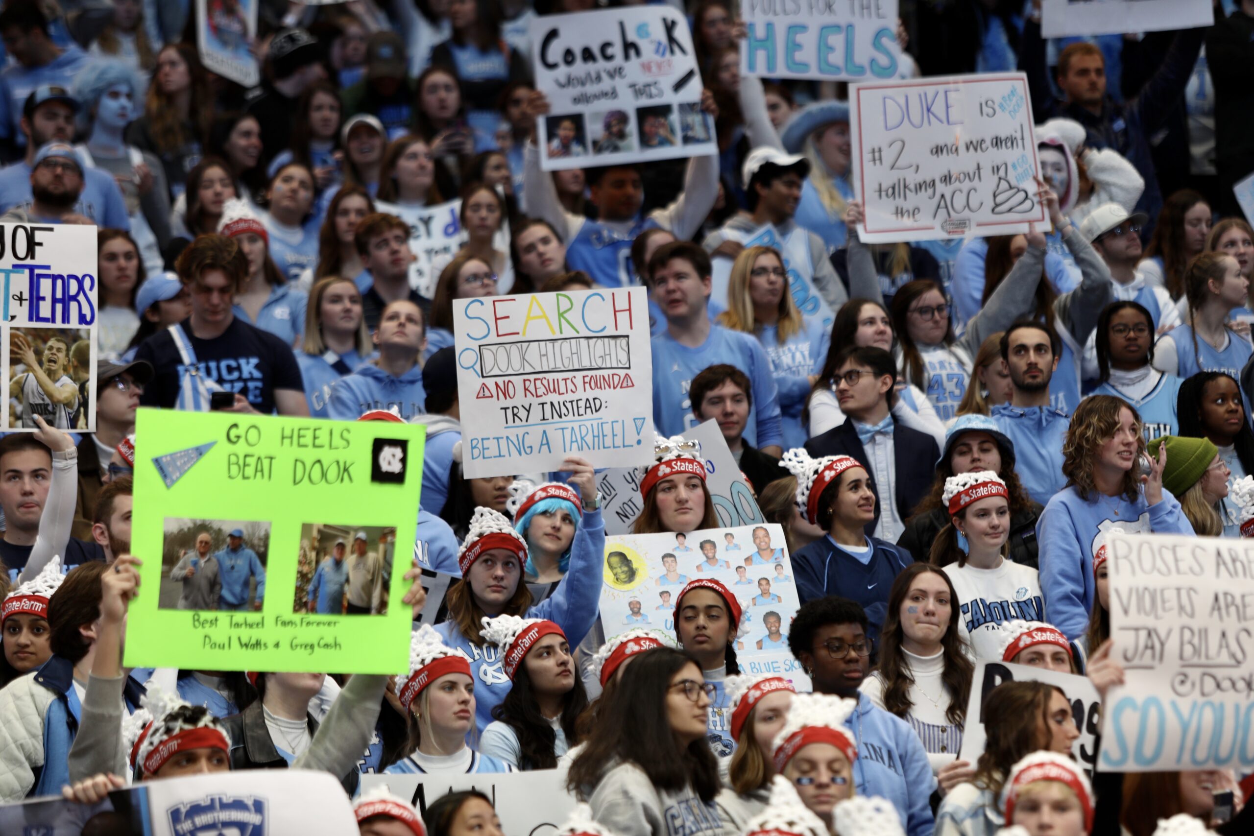 Fans in the stands of the Dean Smith Center holding handmade signs
