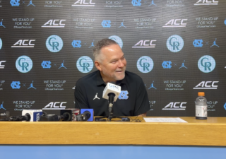 mike malone sitting at podium smiling