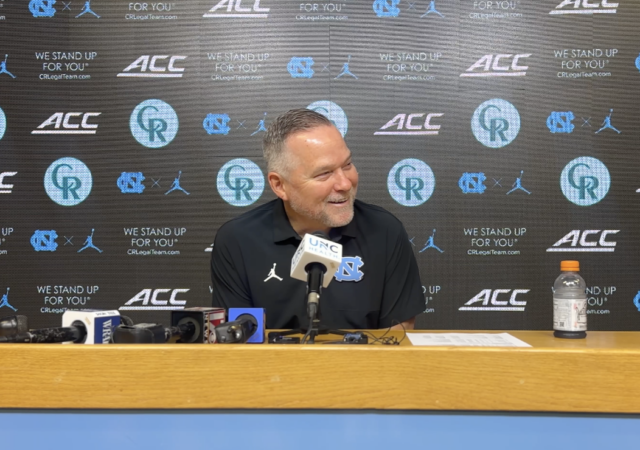 mike malone sitting at podium smiling